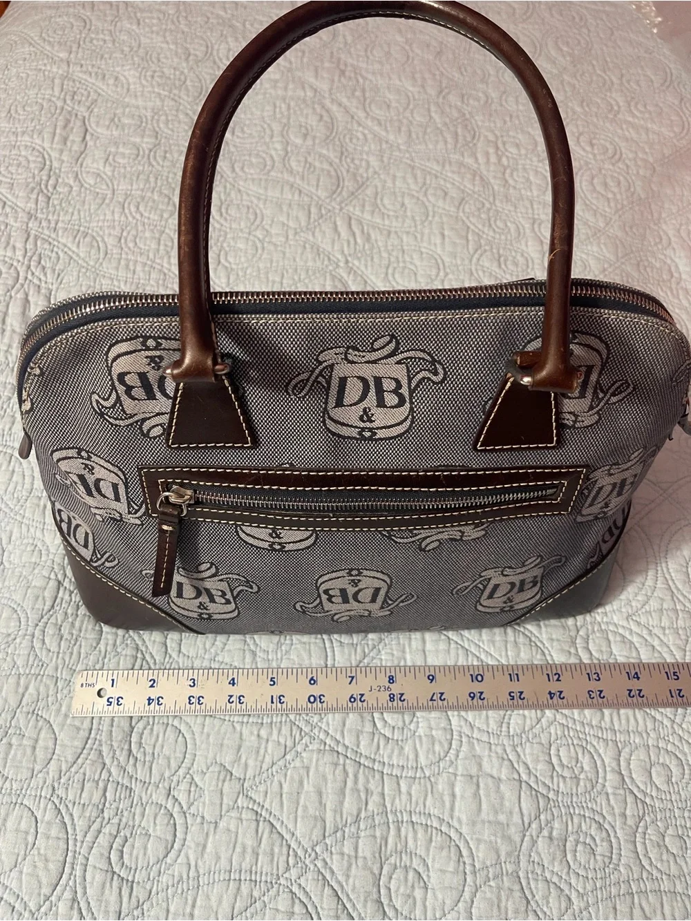 Dooney and Bourke Monogram Denim Donegal Dome Satchel with brown leather trim.